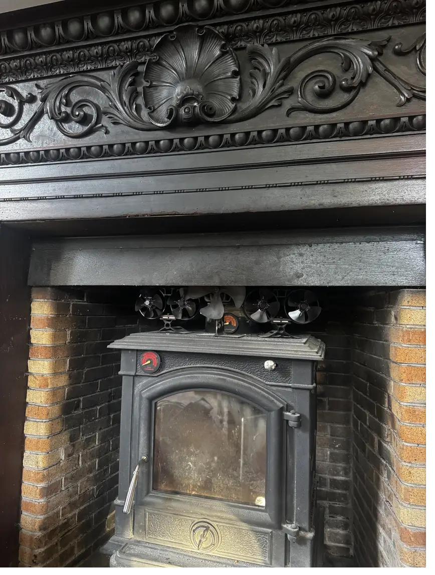 Cast-iron stove set into a Victorian fireplace
